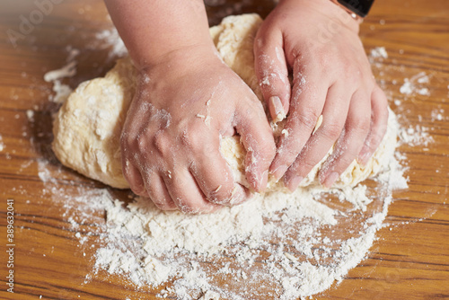 Close up of female hands kneading dough at home