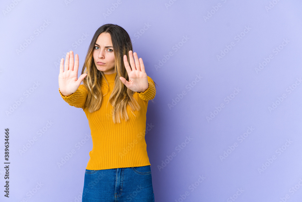Young caucasian woman isolated on purple background standing with outstretched hand showing stop sign, preventing you. Young caucasian woman isolated on purple background standing with outstretched hand showing stop sign, preventing you.