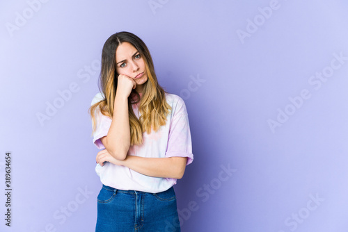 Young caucasian woman isolated on purple background who feels sad and pensive, looking at copy space. © Asier