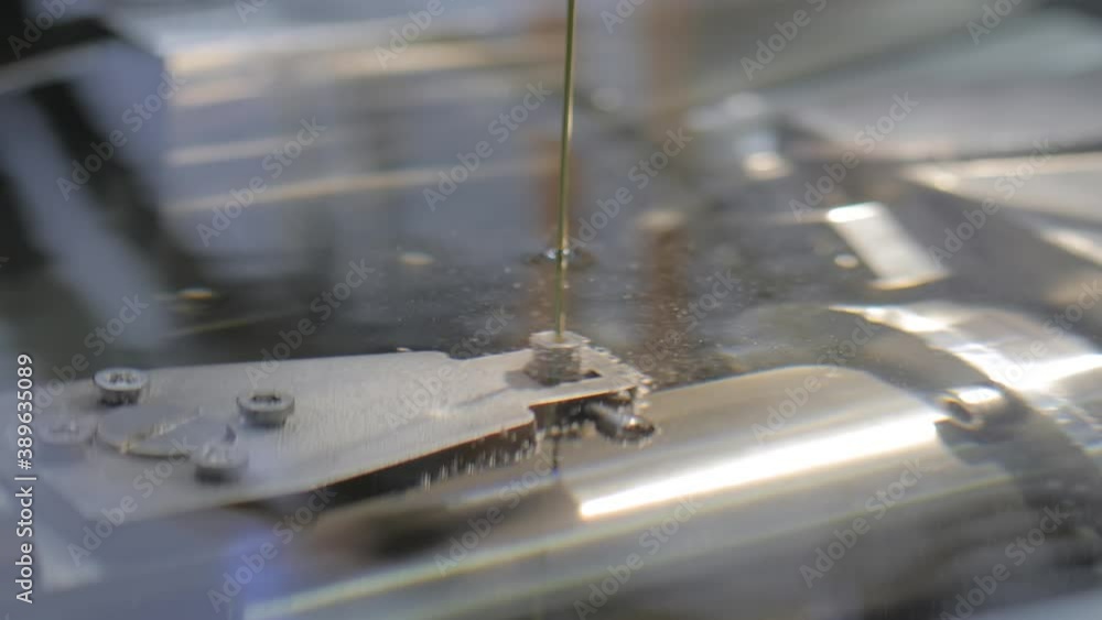 Metalworking, industrial, machining, technology, manufacturing, equipment concept. Automatic electric cnc wire cutting machine working with metal workpiece at factory, plant Metalworking, industrial, machining, technology, manufacturing, equipment concept. Automatic electric cnc wire cutting machine working with metal workpiece at factory, plant