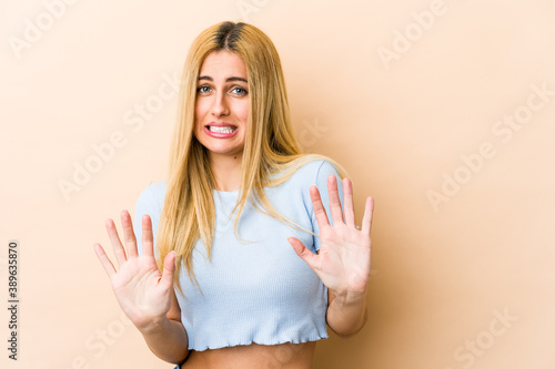 Young blonde caucasian woman rejecting someone showing a gesture of disgust.