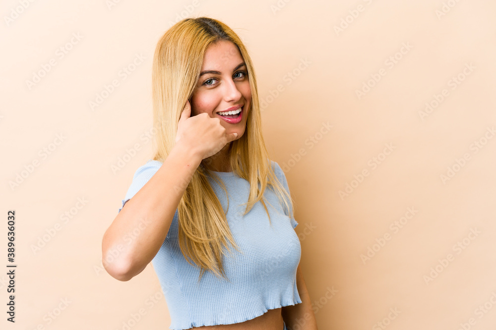 Young blonde caucasian woman showing a mobile phone call gesture with fingers. Young blonde caucasian woman showing a mobile phone call gesture with fingers.