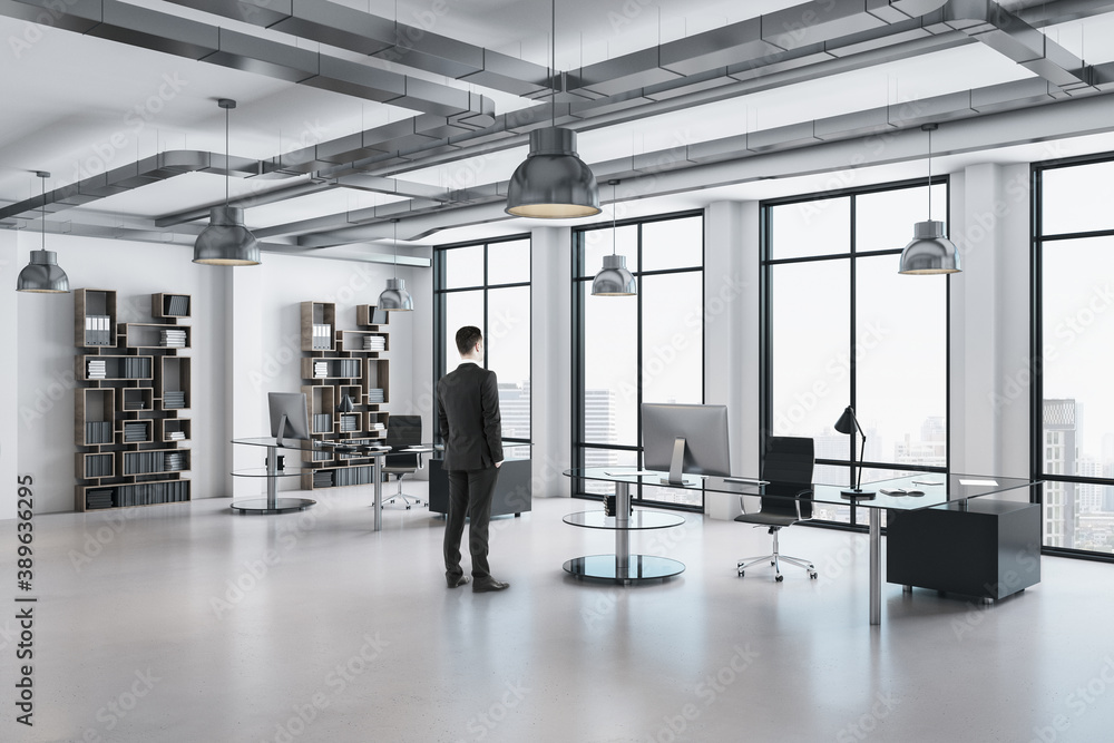 Businessman standing in panoramic open space modern office Businessman standing in panoramic open space modern office