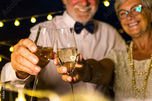 couple of two old and mature seniors enjoying and having fun together celebrating the new year night drinking and clinking 