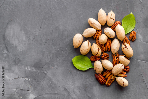 Pile of pecan nuts with leaves. Flat lay, top view
