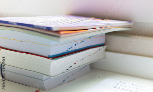 stack of books on a table waiting to be opened for study.