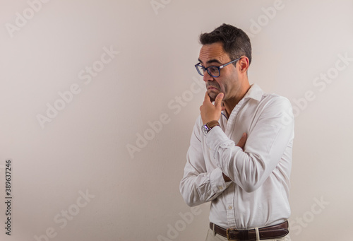 thinking man on neutral background to place text on one side.