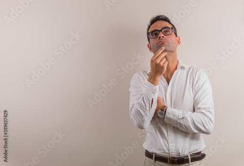 thinking man on neutral background to place text on one side.