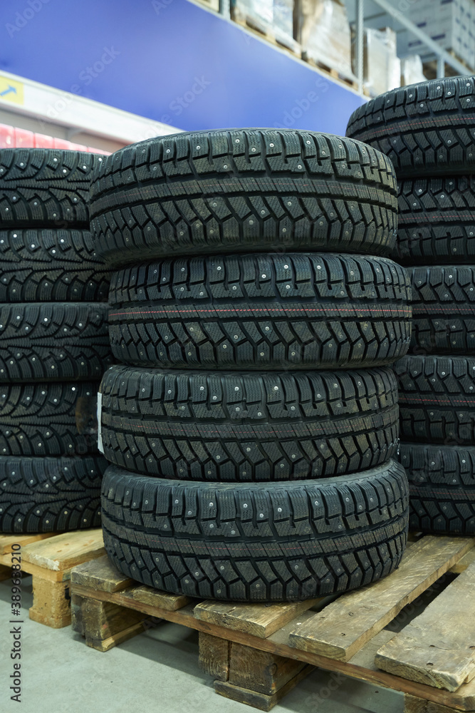 New winter car tires lie on the pallet in a store