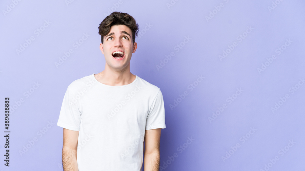 Young caucasian man isolated on purple background shouting very angry, rage concept, frustrated. Young caucasian man isolated on purple background shouting very angry, rage concept, frustrated.