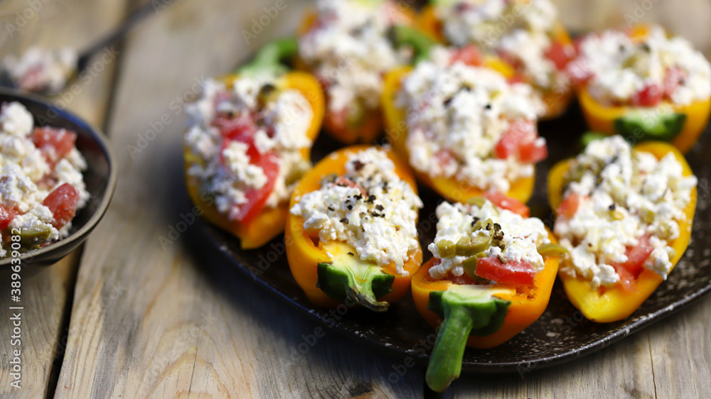 Selective focus. Macro. Yellow paprika peppers stuffed with ricotta cheese with vegetables. Keto snack. The keto diet. Selective focus. Macro. Yellow paprika peppers stuffed with ricotta cheese with vegetables. Keto snack. The keto diet.