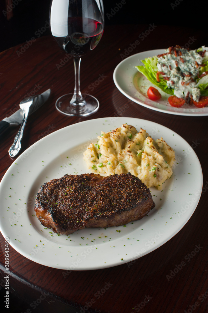 Steak dinner w/ vegetables. Traditional classical American or French Bistro main course, steak and mashed potatoes. Steak, cooked medium rare served with garlic mashed potatoes and kale salad. Steak dinner w/ vegetables. Traditional classical American or French Bistro main course, steak and mashed potatoes. Steak, cooked medium rare served with garlic mashed potatoes and kale salad.