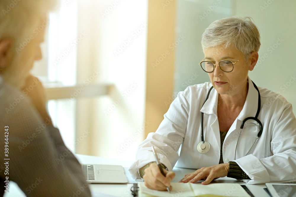 Obraz premium Mature woman doctor in medical consultation with patient