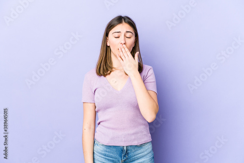 Young caucasian woman yawning showing a tired gesture covering mouth with hand.