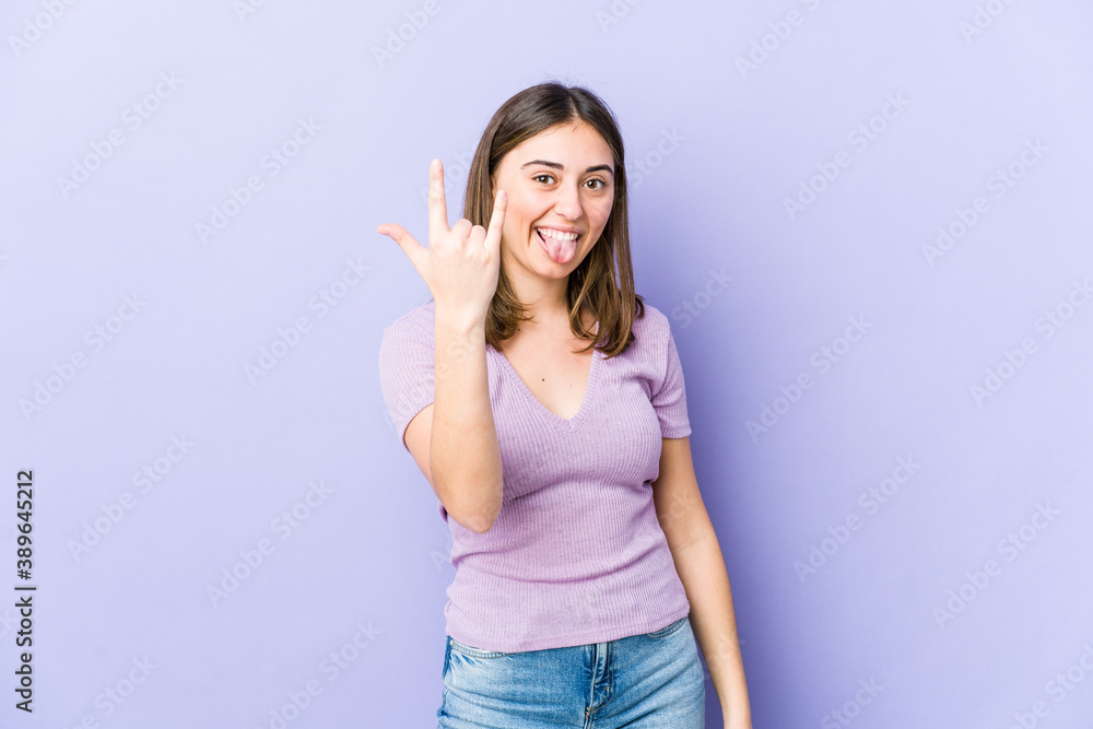 Young caucasian woman showing rock gesture with fingers Young caucasian woman showing rock gesture with fingers
