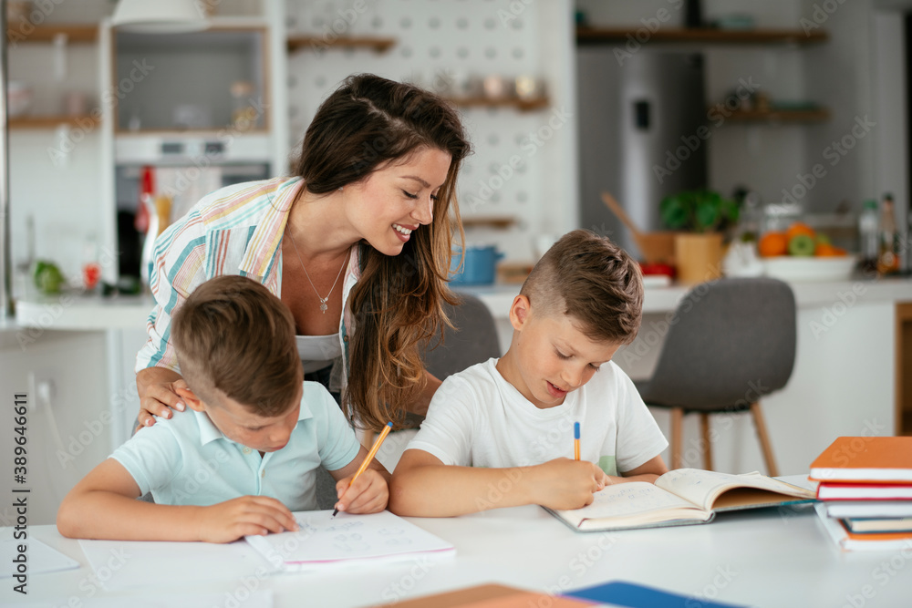 Mother helping her son with homework at home. Little boy learning at home.