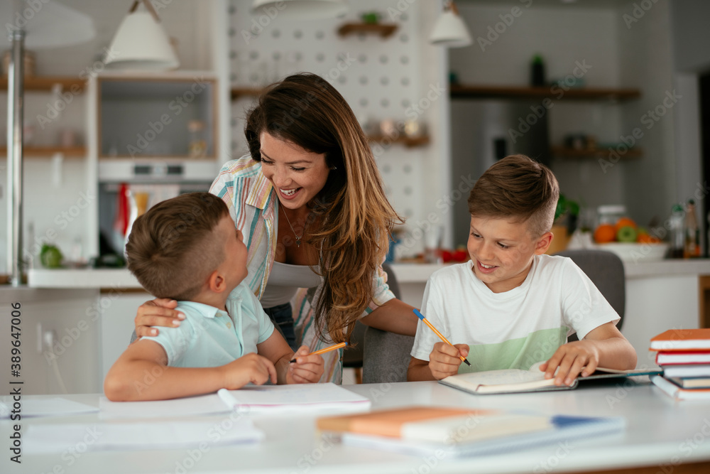 Mother helping her son with homework at home. Little boy learning at home. Mother helping her son with homework at home. Little boy learning at home.