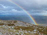 A rainbow appears over the lower peak of Croagh Patrick in County Mayo, Ireland. 