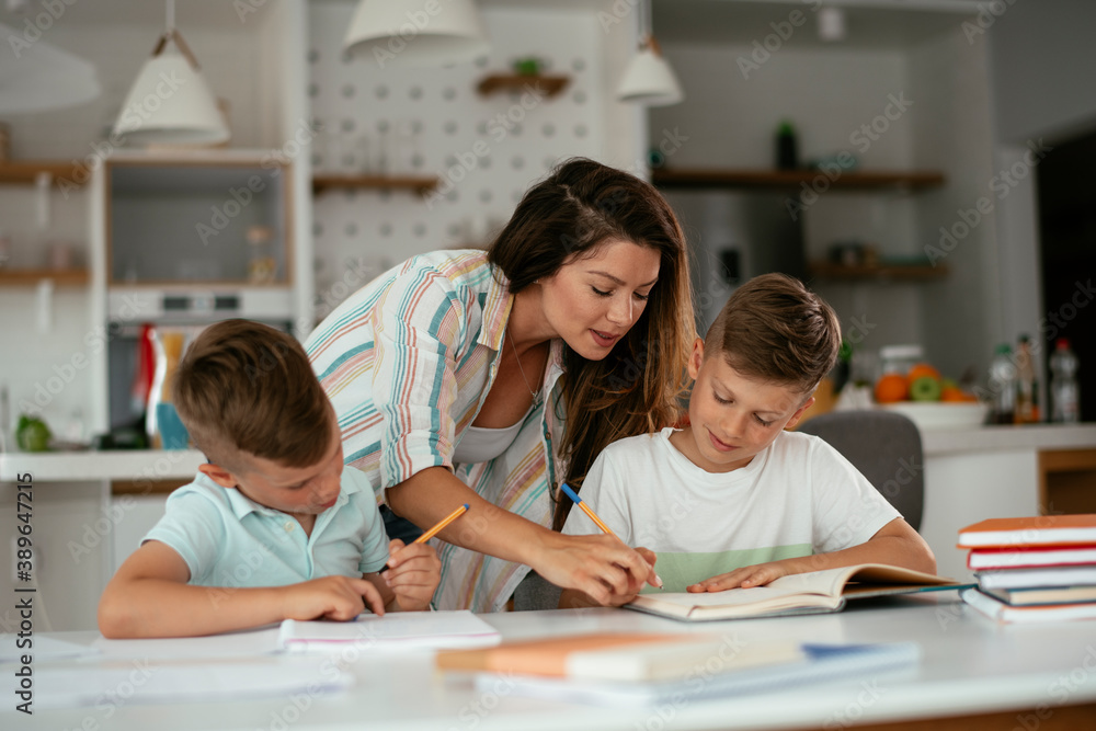 Mother helping her son with homework at home. Little boy learning at home. Mother helping her son with homework at home. Little boy learning at home.