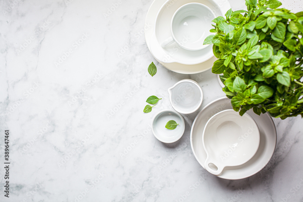 Empty clean gray and white plates and bowls on white marble background, copy space. Cooking background. Empty clean gray and white plates and bowls on white marble background, copy space. Cooking background.