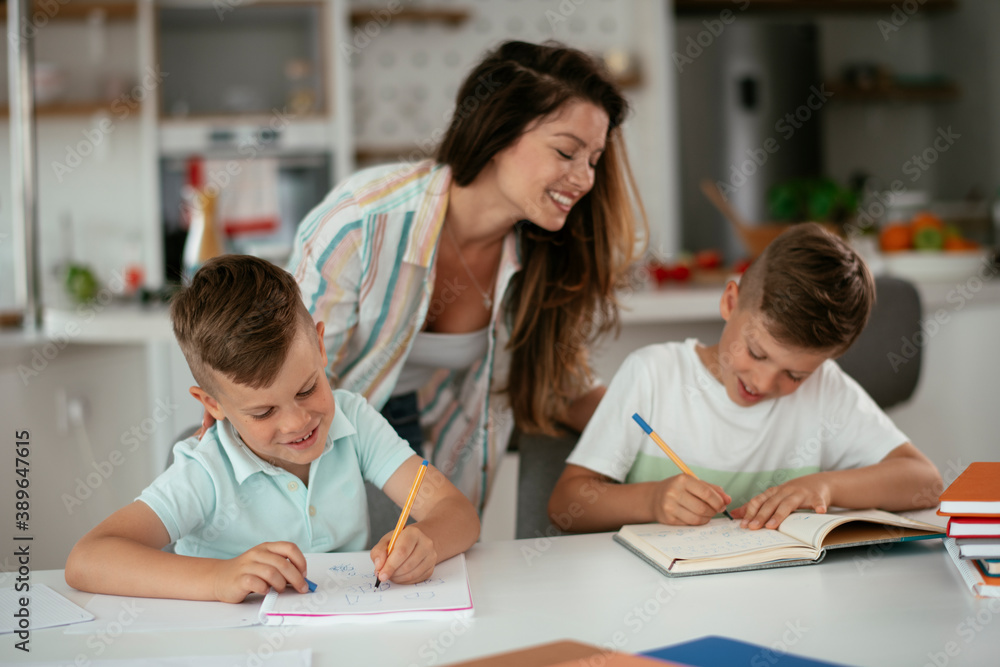 Mother helping her son with homework at home. Little boy learning at home.