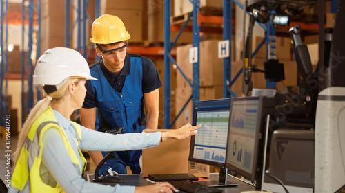 In Retail Warehouse Manager Uses Computer with Inventory Checking Software, Talks with Storehouse Worker about Package Delivery. International Distribution Center with Shelves Full of Products 