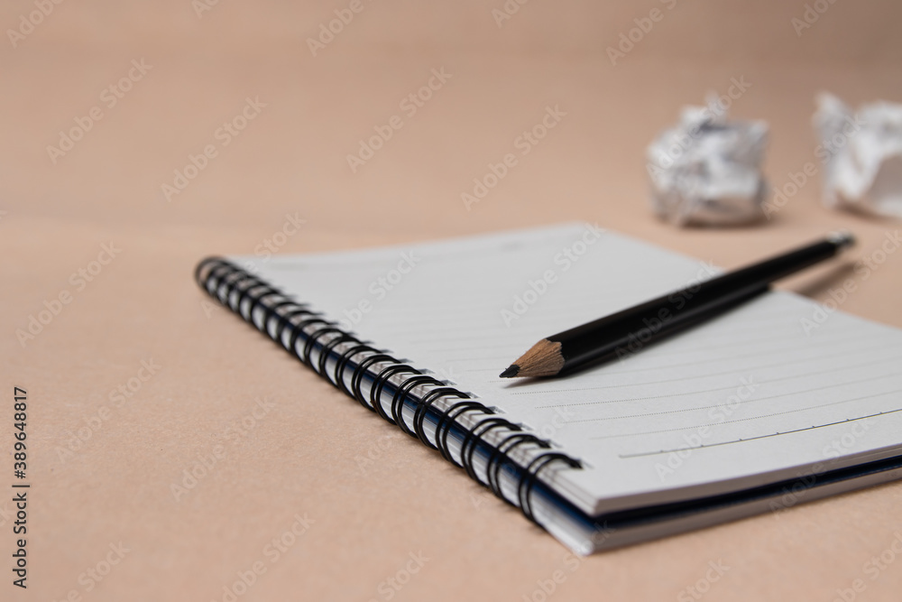 Notepad or notebook with pencil on pink background
