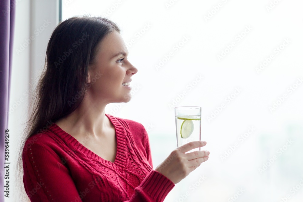 Young smiling woman with glass of water with lime Young smiling woman with glass of water with lime