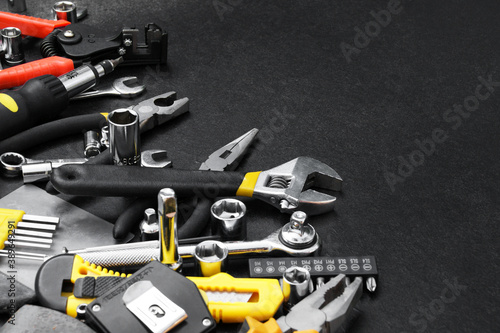 Many different tools for repair work on a black background with copy space for text.