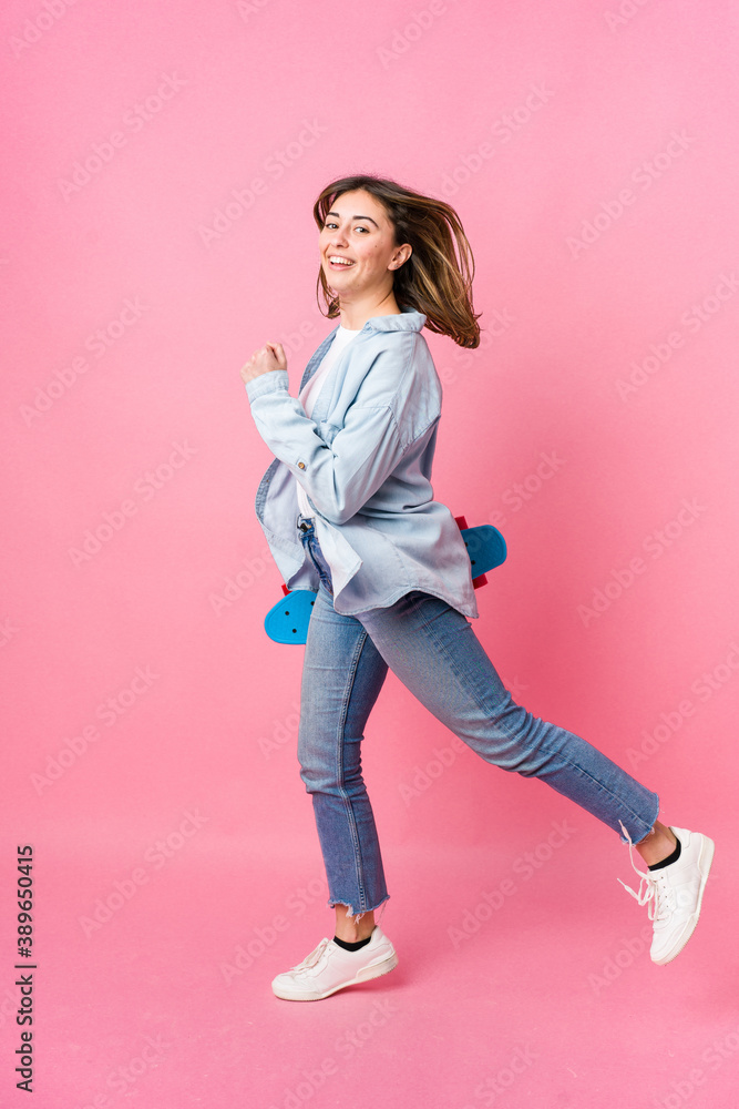 Young skater woman isolated on pink background Young skater woman isolated on pink background