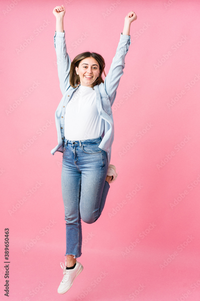 Young woman jumping on pink background Young woman jumping on pink background