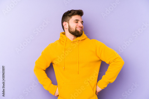 Young man isolated on purple background dreaming of achieving goals and purposes