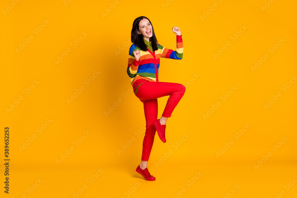 Full body photo of happy smile positive girl celebrate win victory fists hands yell yes isolated over yellow color background