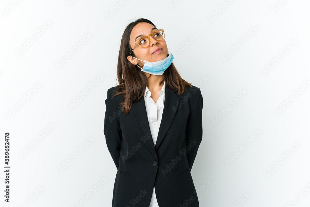 Young business latin woman wearing a mask to protect from covid isolated on white background dreaming of achieving goals and purposes Young business latin woman wearing a mask to protect from covid isolated on white background dreaming of achieving goals and purposes