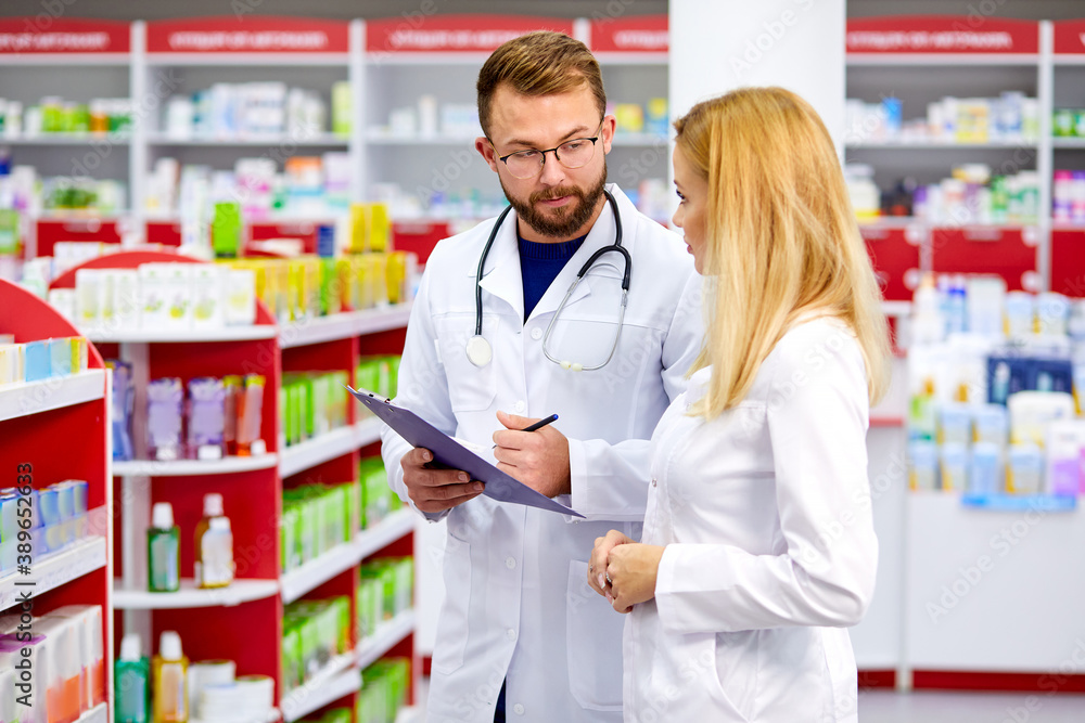 confident male and female druggists talk in pharmacy, professional pharmacists talk about the attributes and side effects of a medicine or pharmaceutical product for sale confident male and female druggists talk in pharmacy, professional pharmacists talk about the attributes and side effects of a medicine or pharmaceutical product for sale