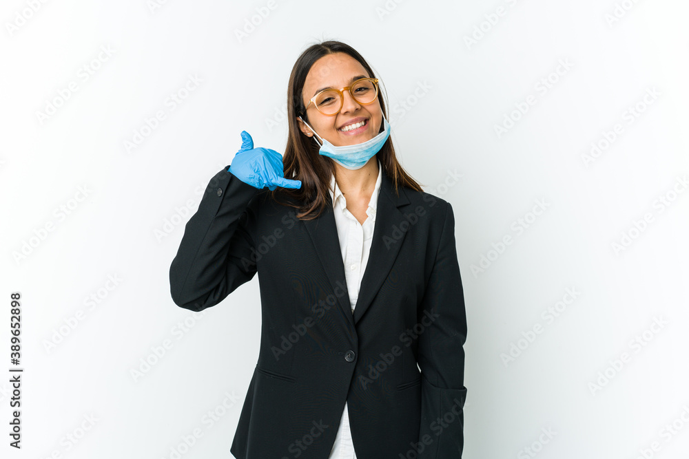 Young business latin woman wearing a mask to protect from covid isolated on white background showing a mobile phone call gesture with fingers. Young business latin woman wearing a mask to protect from covid isolated on white background showing a mobile phone call gesture with fingers.
