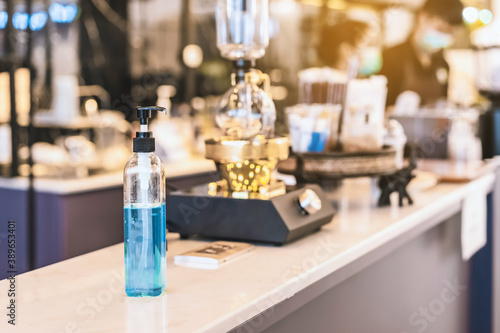 Blue alcohol gel bottle for hands cleaning to prevent the spreading of the Corona virus (Covid-19), Place the entrance service for customers in the cafe. Healthcare concept. New normal lifestyle.