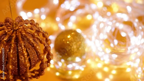 Golden Christmas bokeh of light and twinkling garlands, Christmas ball spinning, blurred focus . background video of the winter holiday