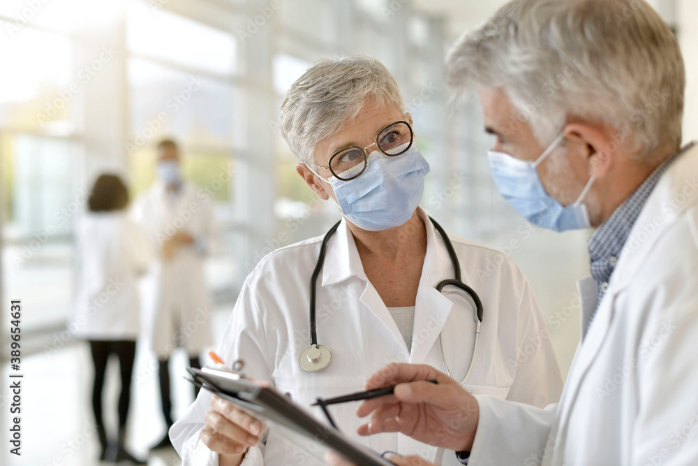 Doctor in hospital giving 19-ncov instructions to colleague Doctor in hospital giving 19-ncov instructions to colleague