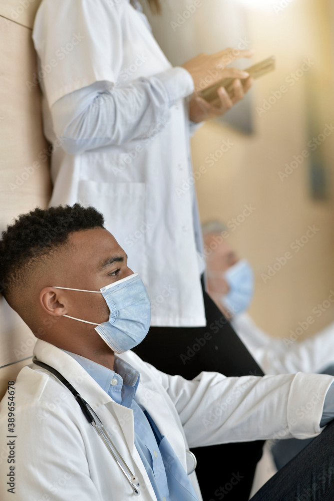 Young doctor taking a break in hospital corridor Young doctor taking a break in hospital corridor