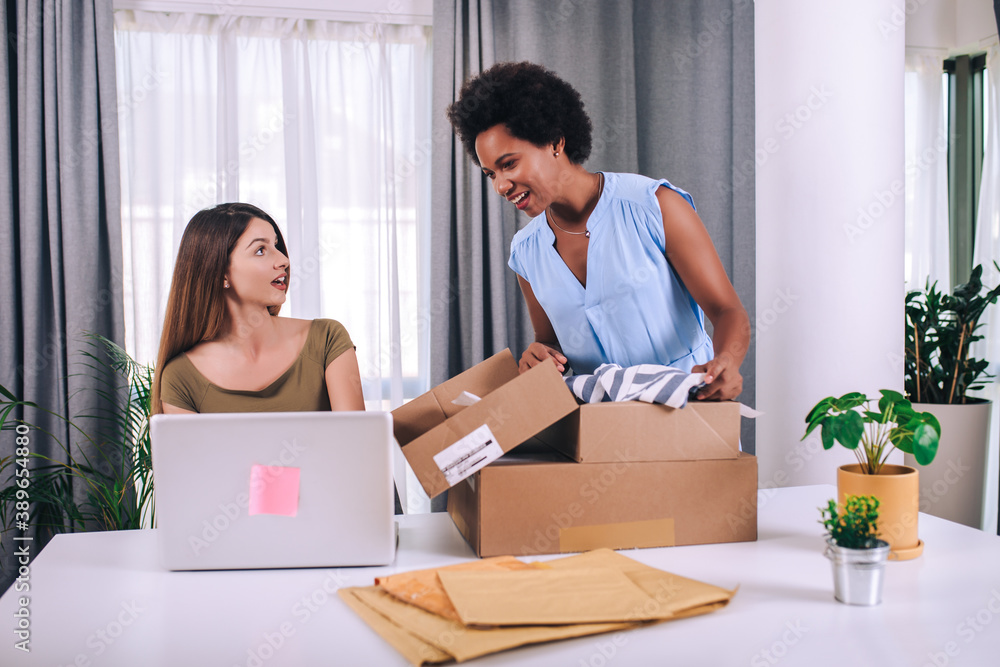 Two young women helped sell their products online and happily prepared to deliver their products. Selling products online or doing freelance work at home concept. Two young women helped sell their products online and happily prepared to deliver their products. Selling products online or doing freelance work at home concept.