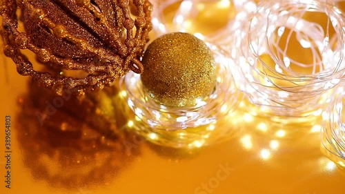 Golden Christmas bokeh from light and twinkling garlands, Christmas ball, blurred focus . background video of the winter holiday