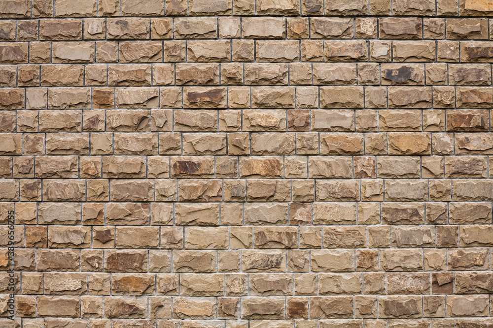 Fototapeta premium Texture of a stone wall. Part of a building wall. Close-up. Place for text.