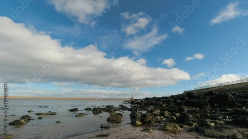 4k Time-lapse footage of Roker Beach with Roker Pier and lighthouse in the distance in Sunderland Tyne and Wear with a stunning vibrant sky filled with voluminous clouds. 