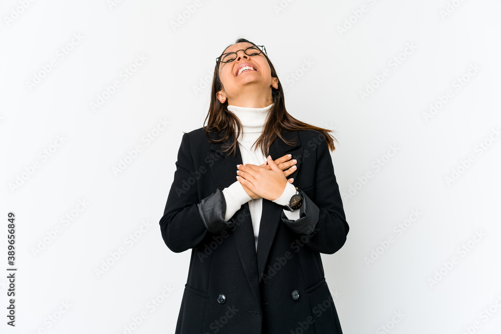 Young mixed race business woman isolated on white background laughing keeping hands on heart, concept of happiness.