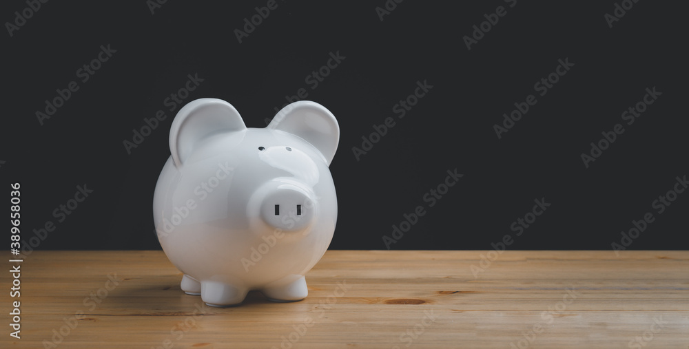 white ceramic piggy bank on wood table white ceramic piggy bank on wood table