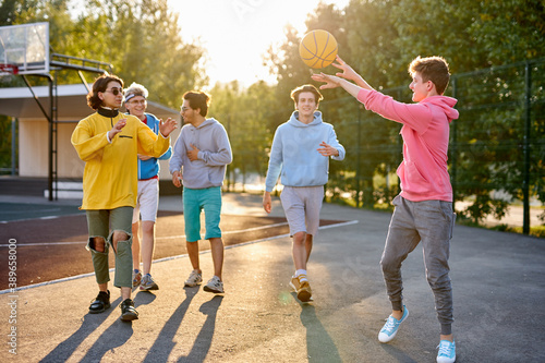 Fotografie energetic, healthy teens have fun, talk before playing basketball, group of happ