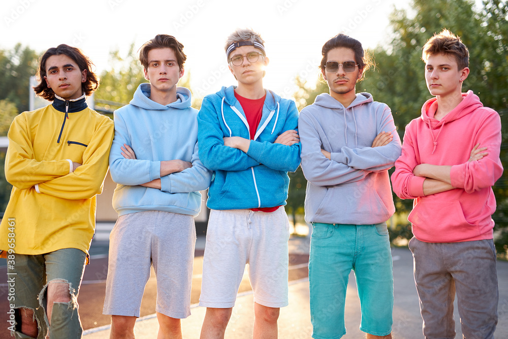 portrait of serious modern boys in casual wear outdoors, caucasian teenagers gathered together , look at camera portrait of serious modern boys in casual wear outdoors, caucasian teenagers gathered together , look at camera