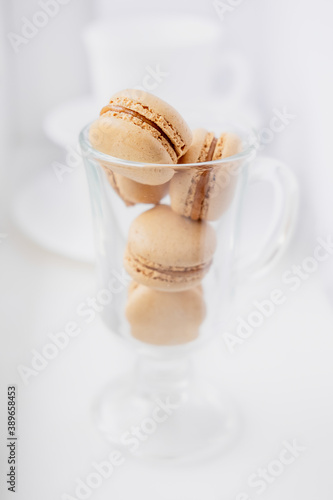 macarons in a coffee cup. caramel macaroons. Light flatley with dessert. Macaroni on white background. Cozy winter photography