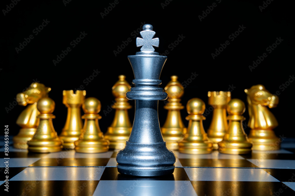 Chess leadership concept with silver and gold chess pieces isolated on black background Chess leadership concept with silver and gold chess pieces isolated on black background